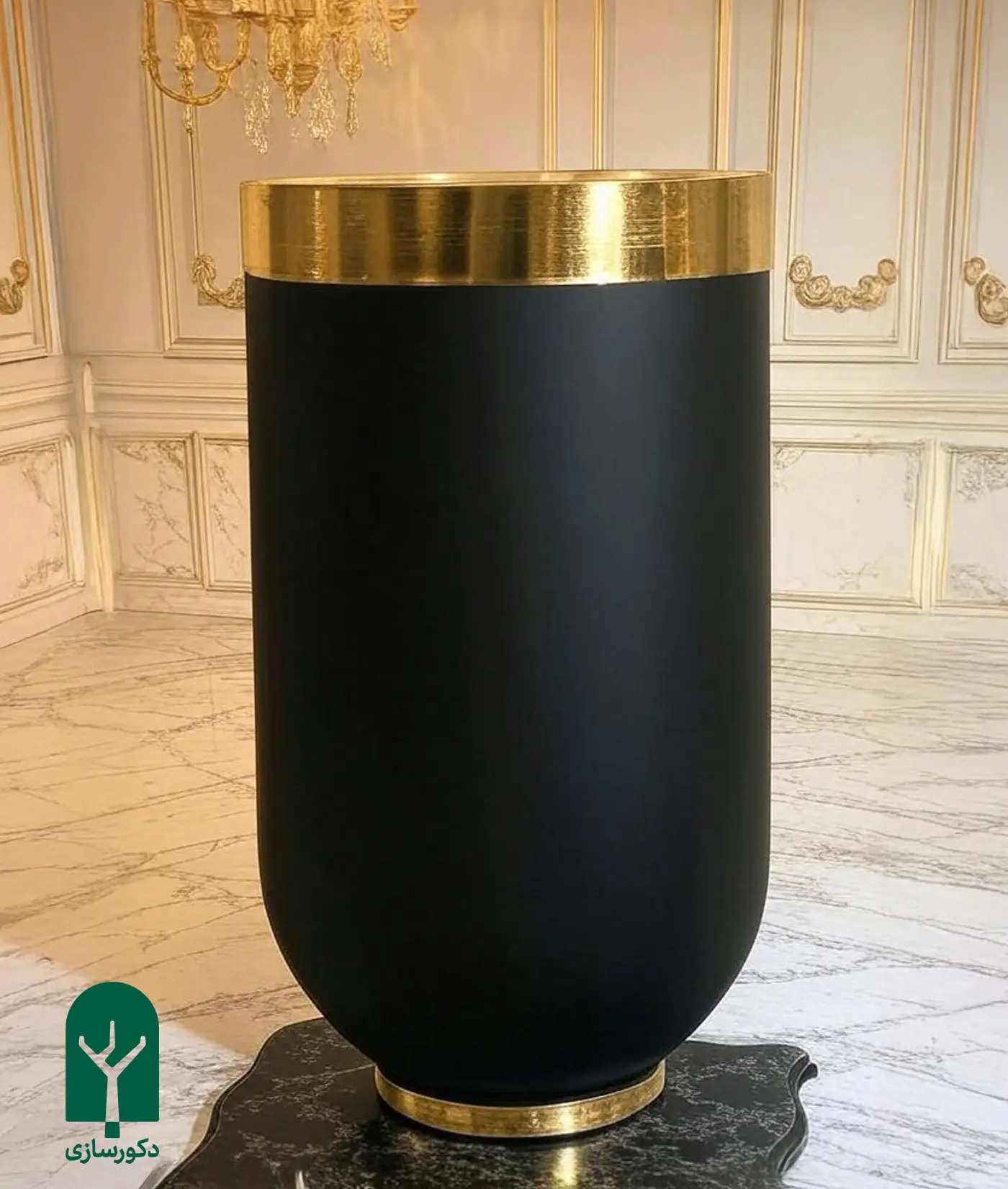 گلدان استوانه ای فایبرگلاس مشکی با لبه استیل طلایی در یک خانه با دیوار های کرم و طلایی با گچ بری سلطنتی